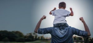 Boy on fathers shoulders cheering