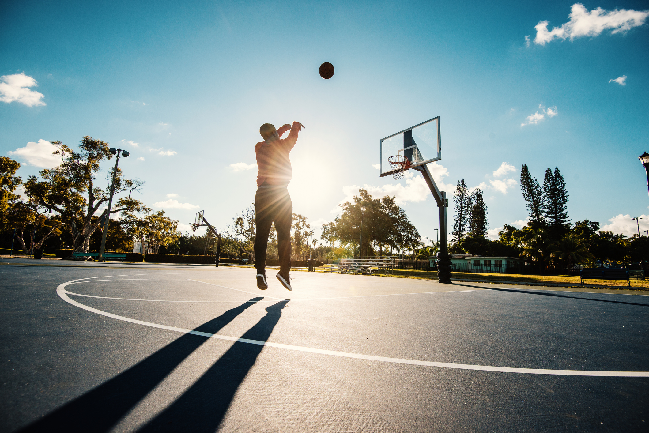 Man shooting basketball on the court in USA in summer Man shooting basketball on the court