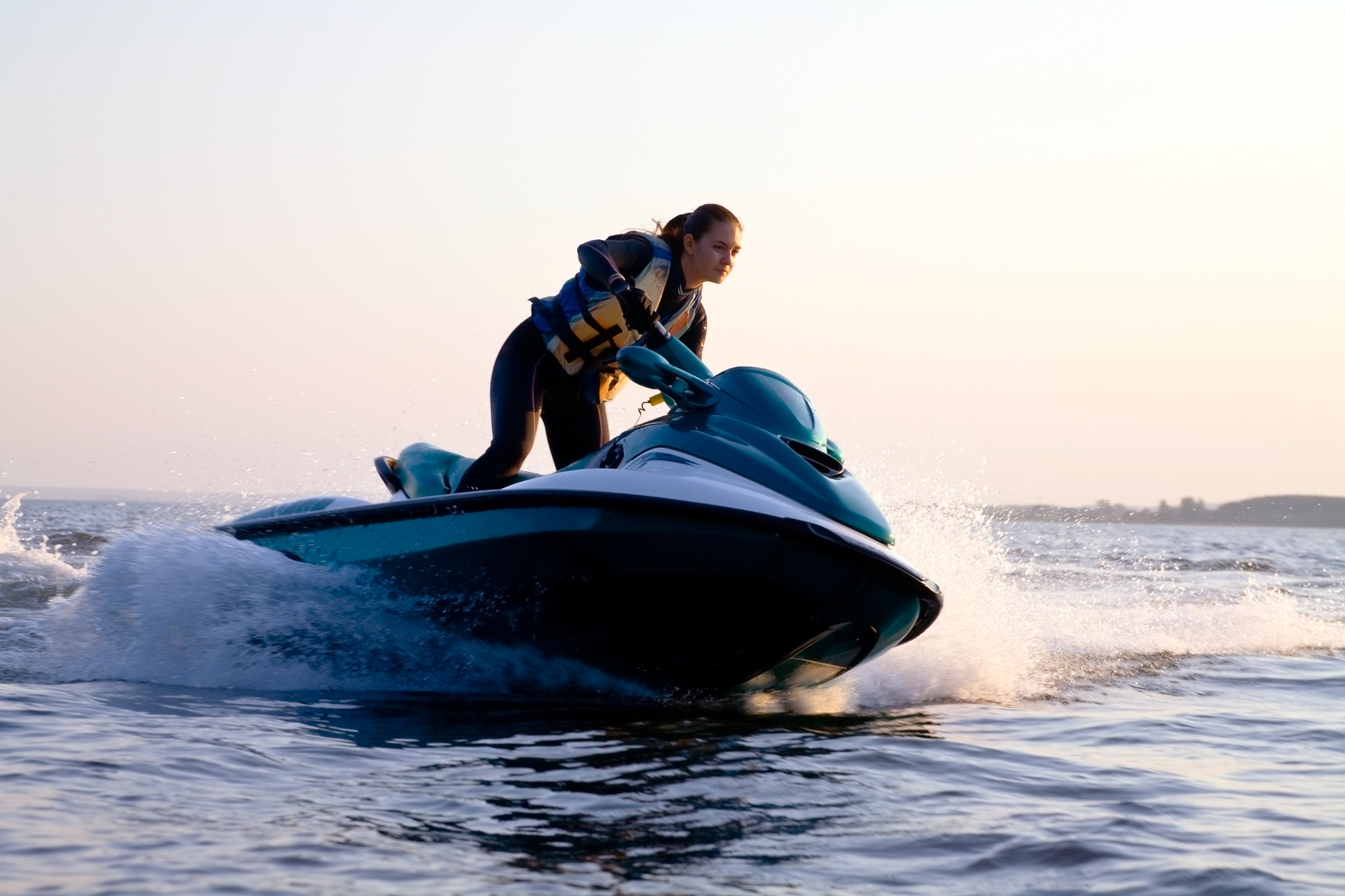 Woman on a jet ski in the ocean during the sunset Female Jet skier