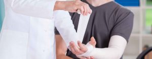 Orthopedist wrappin patient's arm