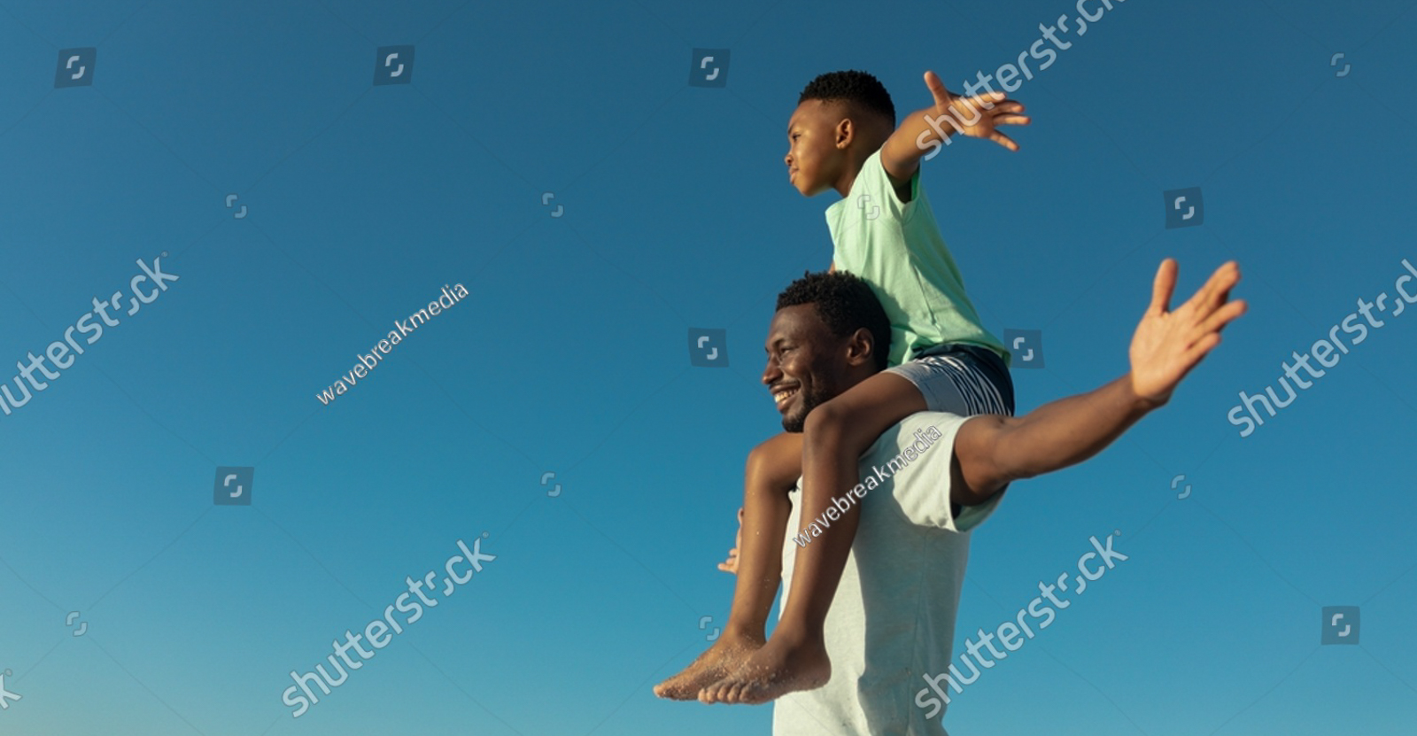 stockphotohappyafricanamericanboyonfathersshouldersbycopy