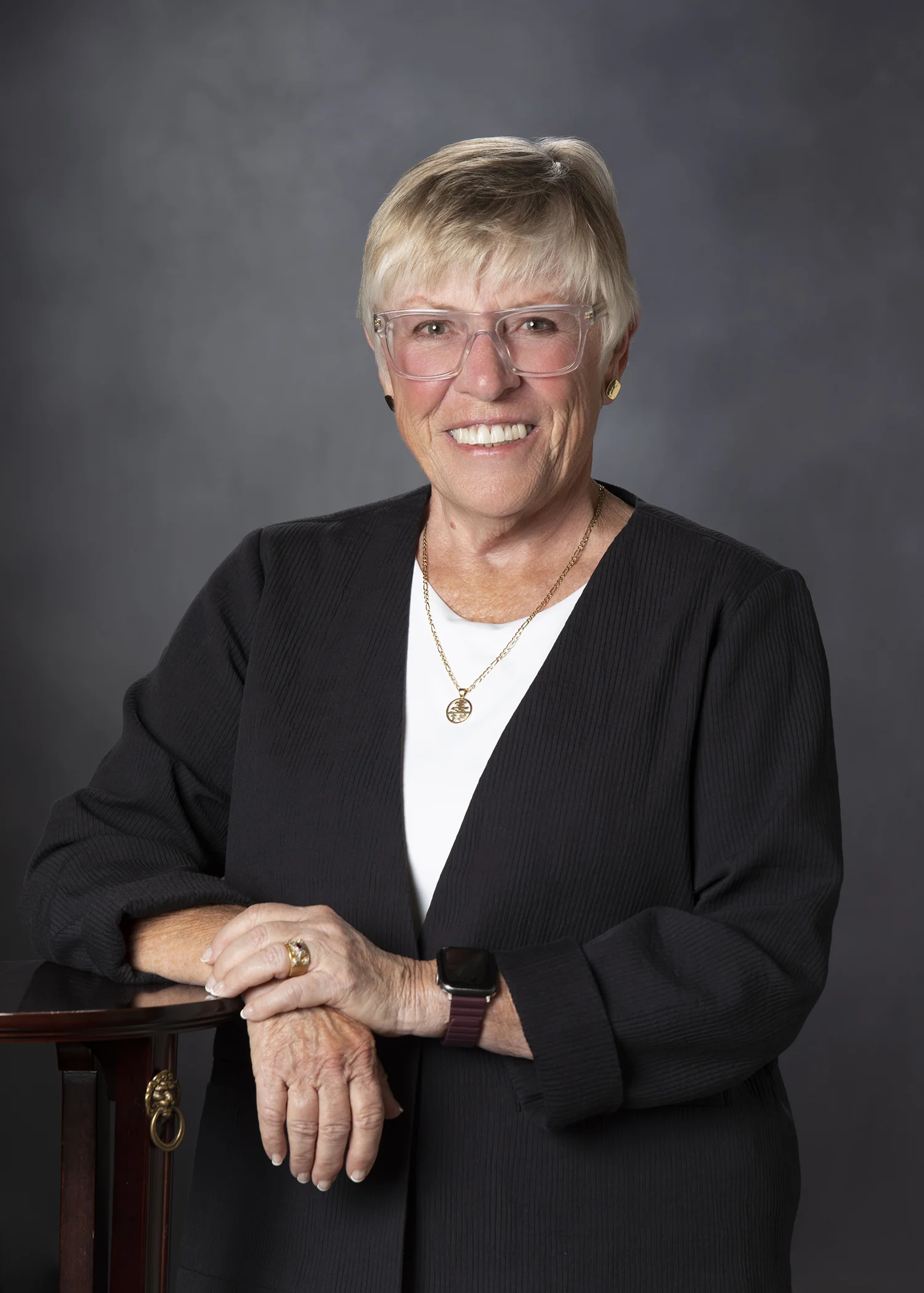 - Atlantic Orthopaedic Specialists - Atlantic Orthopaedic Specialists Professional headshot of an older woman with short gray hair, clear-framed glasses, wearing a black blazer and white top, smiling.